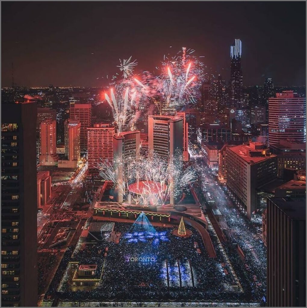 Toronto City Hall pictured from high above, fireworks exploding around